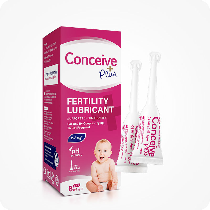 The front view image of the box of Conceive Plus Fertility Lubricant 8x4g pre-filled applicators  and two prefilled applicators placed on the right side beside box on a white background. There prefilled applicators are placed one in front and 2nd behind with partial visibility. A smiling baby is printed on the front side of the box.