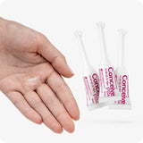 The image of a female left hand entering the frame from the left and three Conceive Plus Fertility Lubricant 3x4g Pre-filled Applicators on the right side of the frame on a white background. The female hand has a small quantity of the lube on its palm and its fingers are closed. The three prefilled applicators are arranged in a triangle shape with one applicator on the front while two behind. The front one covering small parts of the applicators behind.