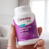 Hand holding a bottle of Conceive Plus Women's Fertility Support Multivitamin